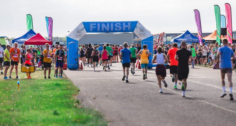 People running through an inflatable arch to a crowd