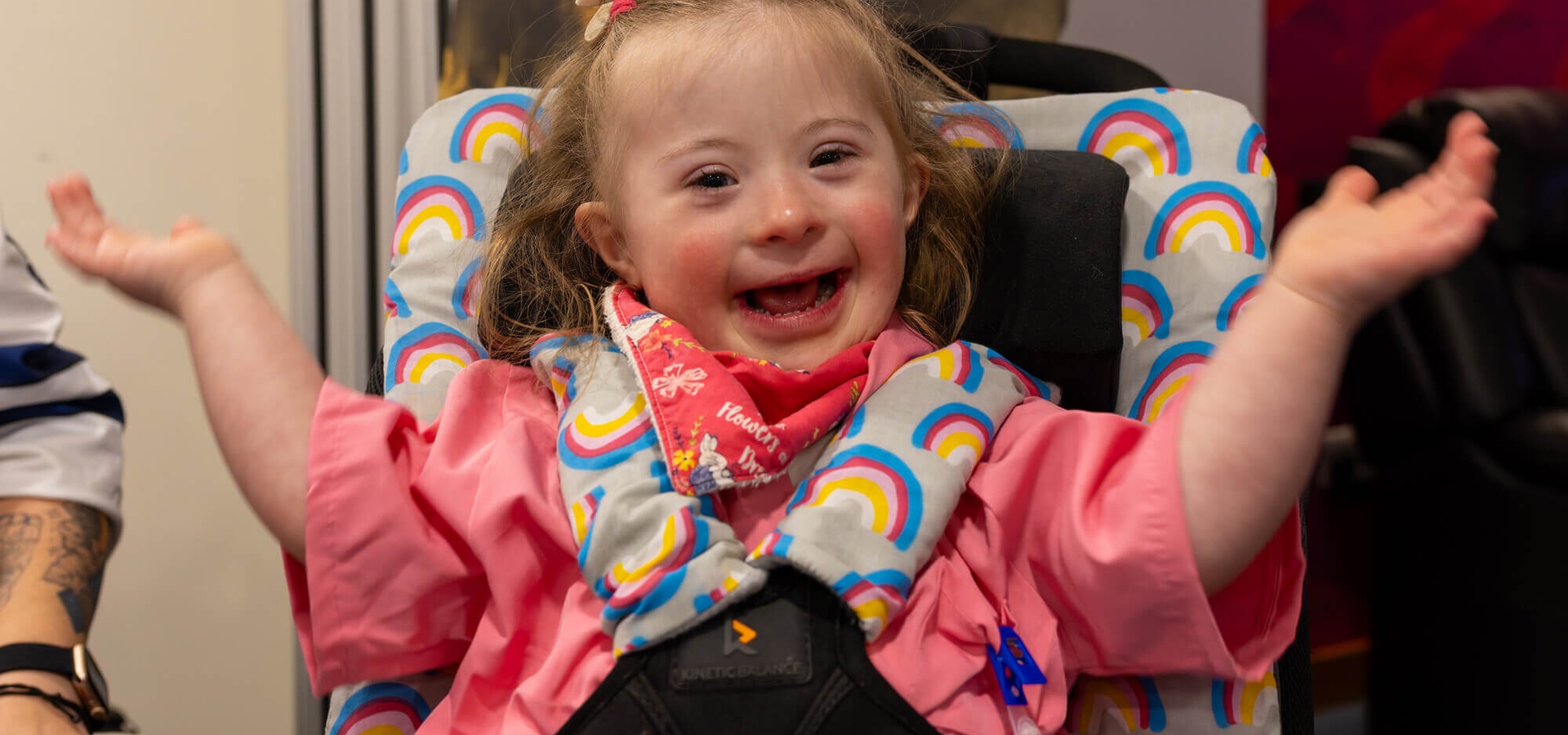 Little girl smiling with hands in air