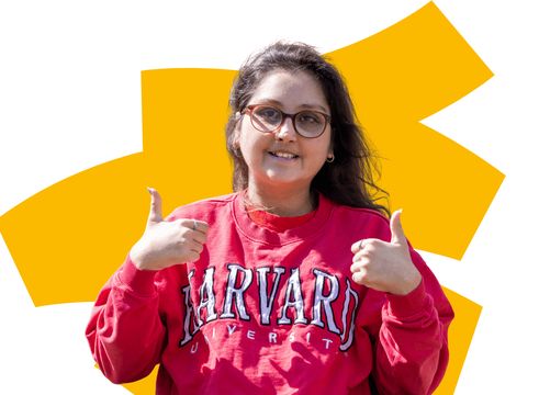 Young woman with red jumper on smiling with thumbs up, on colourful background