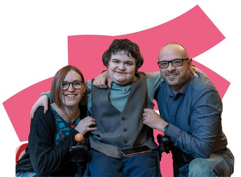 Boy sitting with arms around parents either side, colourful background