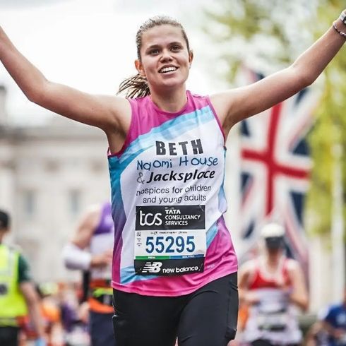 A women with running and smiling by Buckingham Palace