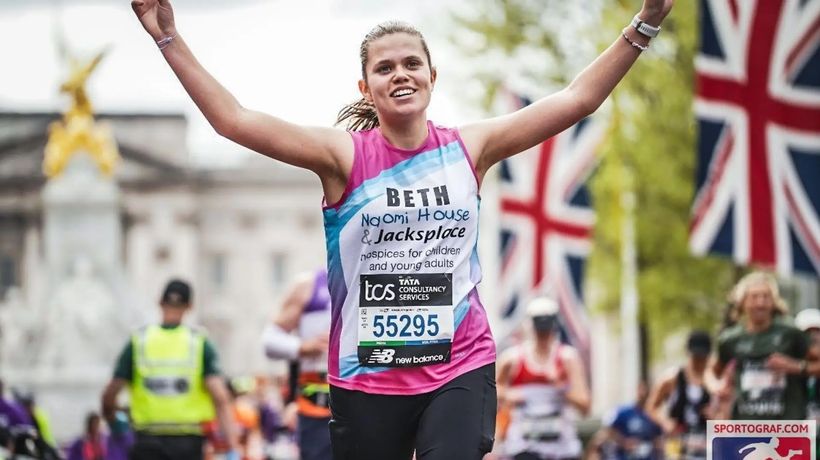 A women with running and smiling by Buckingham Palace
