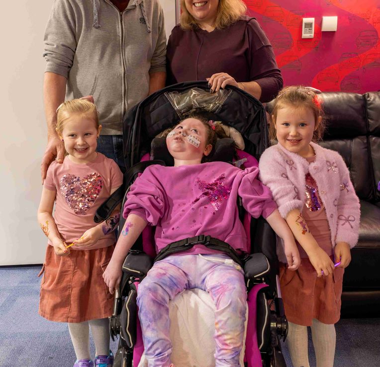 Three girls with mum and dad smiling together