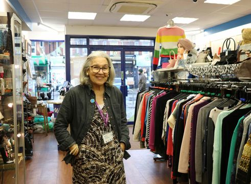 a volunteer woman smiling in a naomi and jacks charity shop