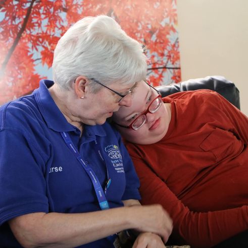 Boy and nurse cuddling on sofa