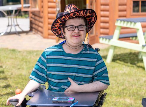 Boy in garden wearing fun hat and glasses