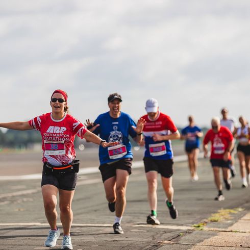A woman running with their arms out like an aeroplane