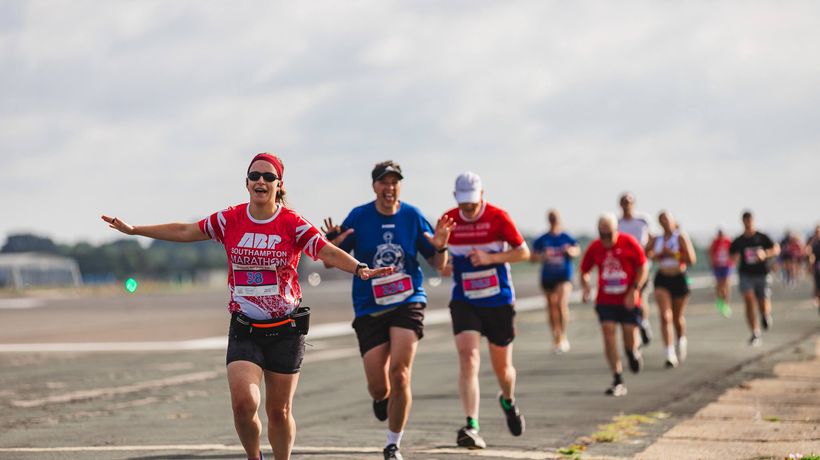 A woman running with their arms out like an aeroplane