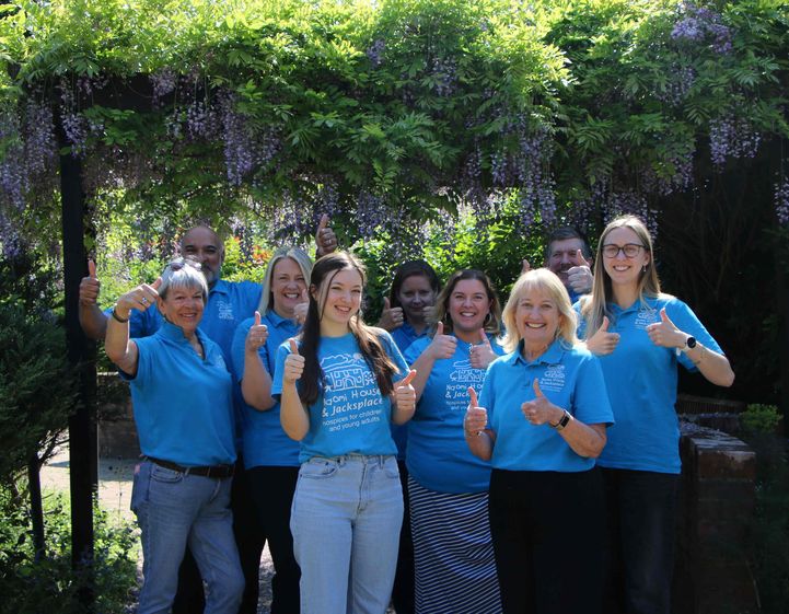 fundraising team in garden showing thumbs up