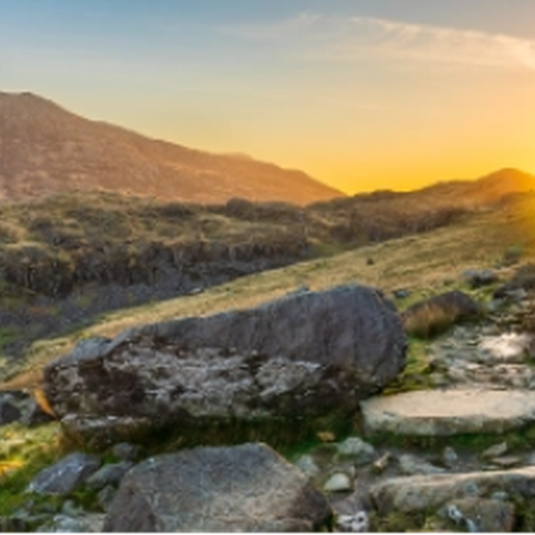 A bright yellow sunrise over a mountain