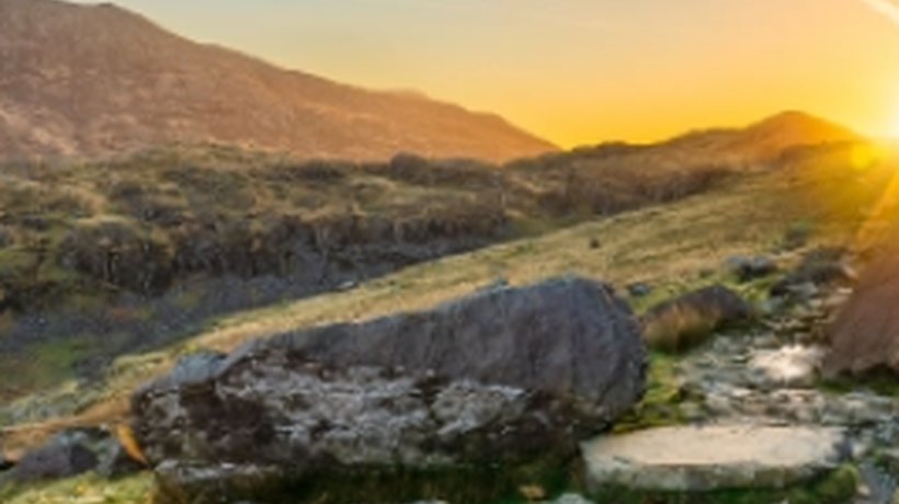 A bright yellow sunrise over a mountain