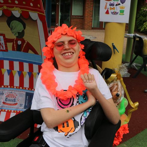 Boy with lei over head and sunglasses on, outdoors