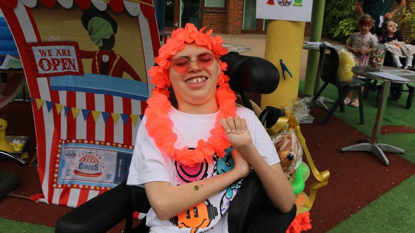 Boy with lei over head and sunglasses on, outdoors