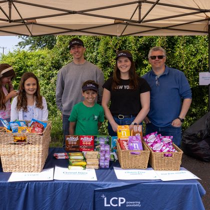 A group of people smiling in front of lots of snacks
